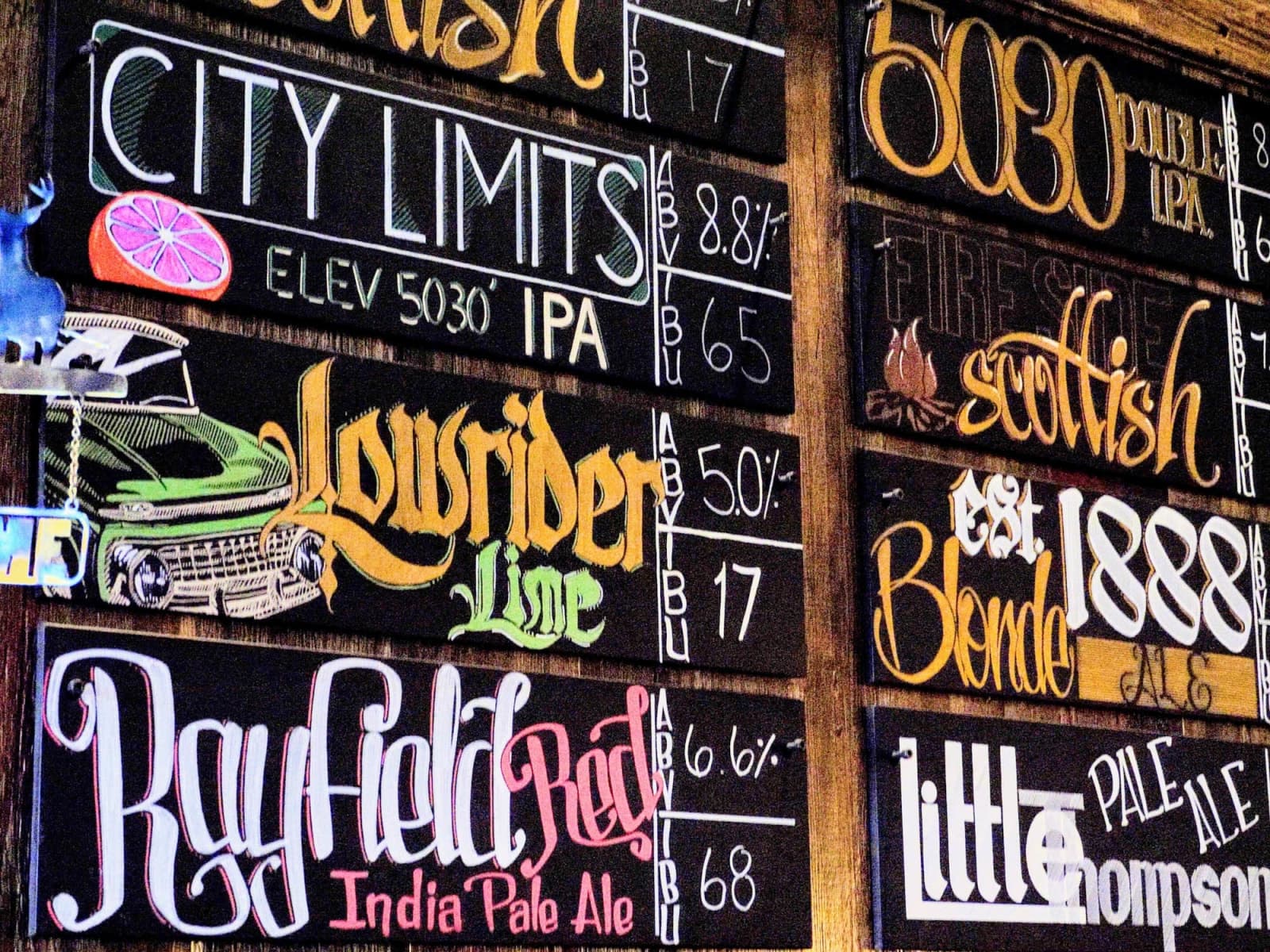 The hand-lettered chalkboard tap list — City Limits, 5030, Lowrider Lime, 1888 Blonde, Little Thompson