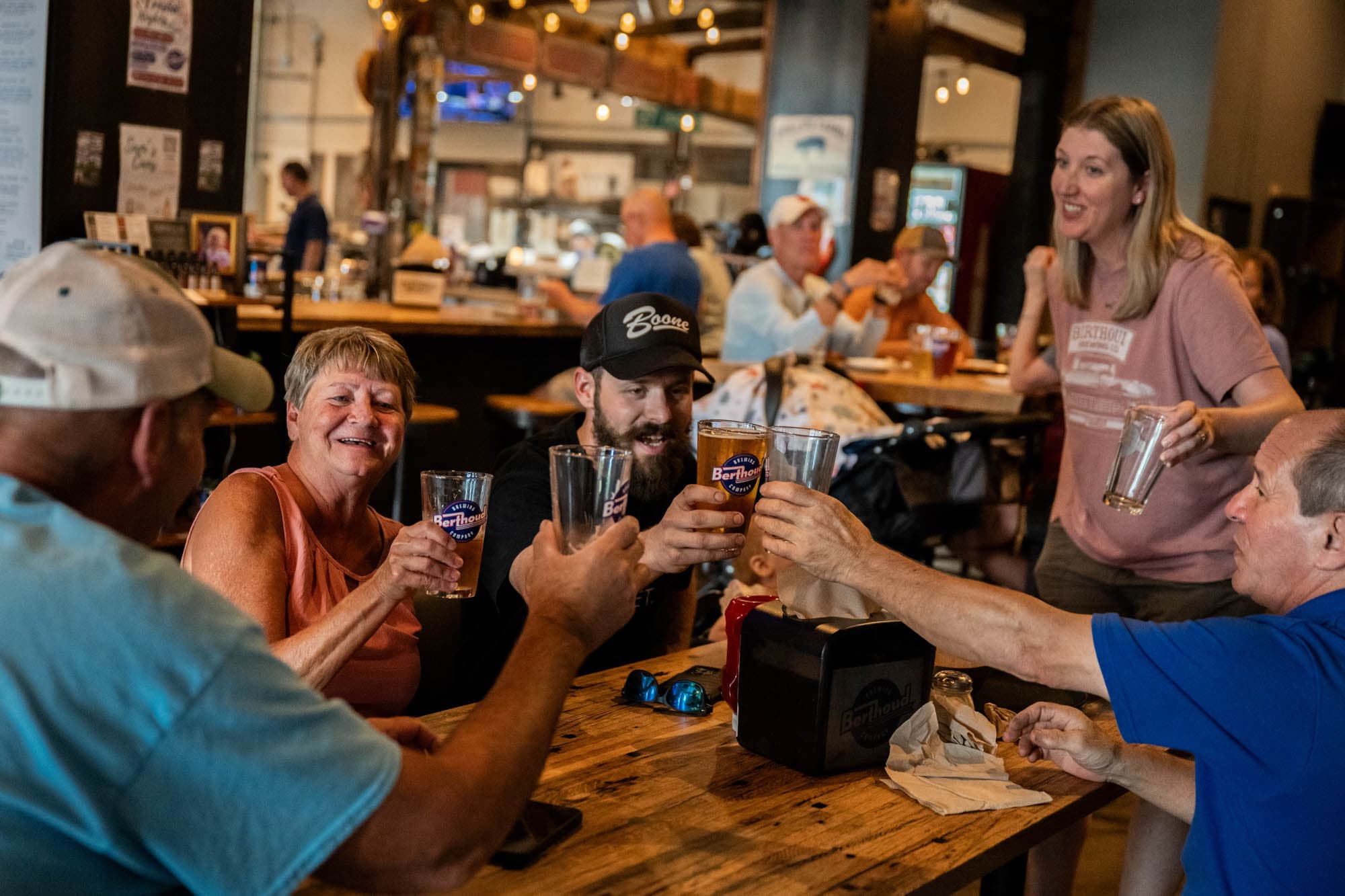 A table of friends raising Berthoud pint glasses